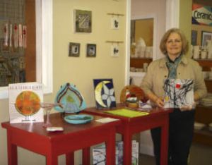 Eastern Wind Glass Owner Dixie Armfield-Rogerson holds up one of her favorite fused glass creations. She teaches stained and fused glass classes inside Claywerks on Callow Avenue in Bremerton.