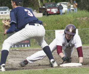 South Kitsap’s Ricky Johnson scampers back to first just ahead of a pickoff attempt during the Wolves’ 8-1 victory over Wilson on Tuesday afternoon in Port Orchard.