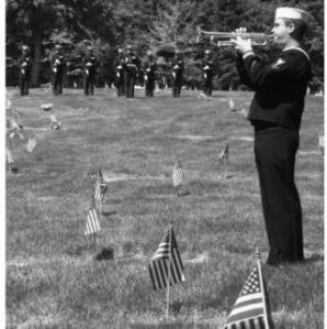 Musician 3rd Class Erik Osberg sounds taps in front of the U.S. Marine Corps Rifle Detail from Marine Corps Security Force Company