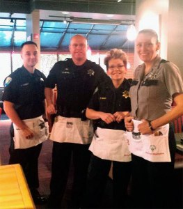 Donning aprons instead of duty belts and waiting to take patron orders during the annual ‘Tip-A-Cop’ fundraiser at Silverdale’s Red Robin Restaurant