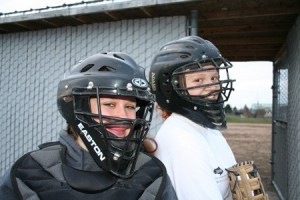 Olympic High School fastpitch catchers Brittany Bird (left) and Sydney Thompson pose after practice Monday. The two will rotate catching duties this season to help Bird as she recovers from knee problems suffered last year. Both agreed that the position takes its toll when working behind the plate