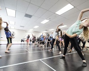 Cast members stretch before a rehearsal for KCMT's 'Mary Poppins.' The theater group