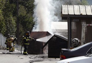 Poulsbo Fire Department and Navy Region Northwest firefighters cool the area around a Dumpster fire Tuesday morning. The Dumpster contained titanium shavings and had to burn itself out.