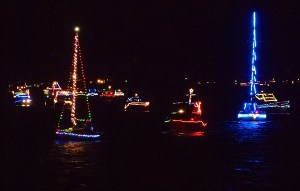 Boats with the Bremerton Yacht Club sail past the Silverdale Waterfront Park pier during BYC's annual Lighted Boat Parade Dec. 19. Several dozen people stood on the pier in the cold