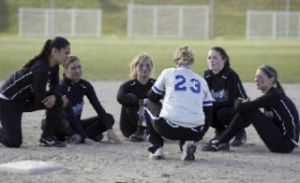 Olympic softball coach Rachel Davenport (23) consults her five seniors following Thursday’s 16-0 win against Bremerton