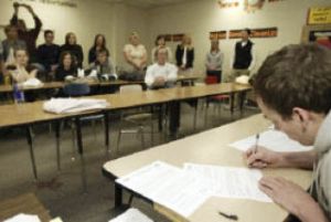 Central Kitsap swimmer Seth Parker signs his letter of intent for Brigham Young University as friends and family look on.