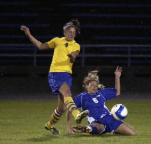 Bremerton alum Naomi Abad (4) avoids a slide tackle from former Olympic Trojan Kayleigh (Badger) Carlson last season. The two are now teammates at OC.