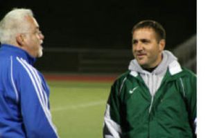 Steve Haggerty (left) jokes with KSS coach Troy Oeschlager before Tuesday’s game. Olympic won 1-0.
