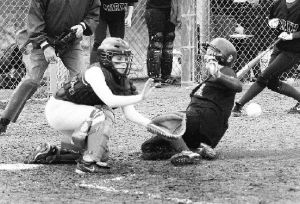 (Above) North Kitsap player Heather Martin slides home safe as Kingston’s Hannah Knight goes for the tag in the fifth inning of action at North Kitsap Thursday.  (Below) Kingston pitcher Kendal Peiguss help lead KHS to a win over NK Thursday during fastpitch action at North.