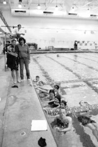 (above) Chad Steyer-Morgan demonstrates  the proper diving technique .  (right) Special Olympics coach Darla Sargent smiles with a handful of the 25 swimmers attending the regional tournament in Kelso today. They’ll compete against 12 other regions and about 1