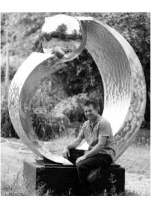 Artist James Kelsey sits next to one of his art works on display at his home in South Colby.