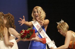 Newly named Miss Kitsap Samantha Przybylek reaches for a hug from her pageant Little Sister Kiana Cheyney as former Miss Kitsap Megan Hornbuckle places her sash.