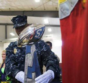 U.S. Navy MASR Isaac McCoy places the trophy on its stand June 27 during the Heroes of 12 Trophy Tour.