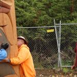 Skokomish artist Andy Wilbur-Peterson watches as crews install his totem pole, &ldquo;Blue Jay & Bear,&rdquo; Quinn Brein / Courtesy