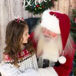 Santa Tim Carter reads to a little girl during a holiday event.                                Photo courtesy of Tim Carter