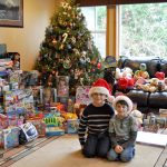 Ryan Downey, left, and Zachary Darner, right, sit surrounded by may of the toys they collected for their Kids Helping Kids toy drive.                                Michelle Beahm / Kitsap News Group