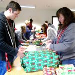 Austin Gese (left) and Laura Gese wrap presents inside the South Kitsap Fire and Rescue&rsquo;s Tremont station Saturday, Dec. 17. Family member John Gese serves as co-chair for the event. Bob Smith | Kitsap Daily News photo