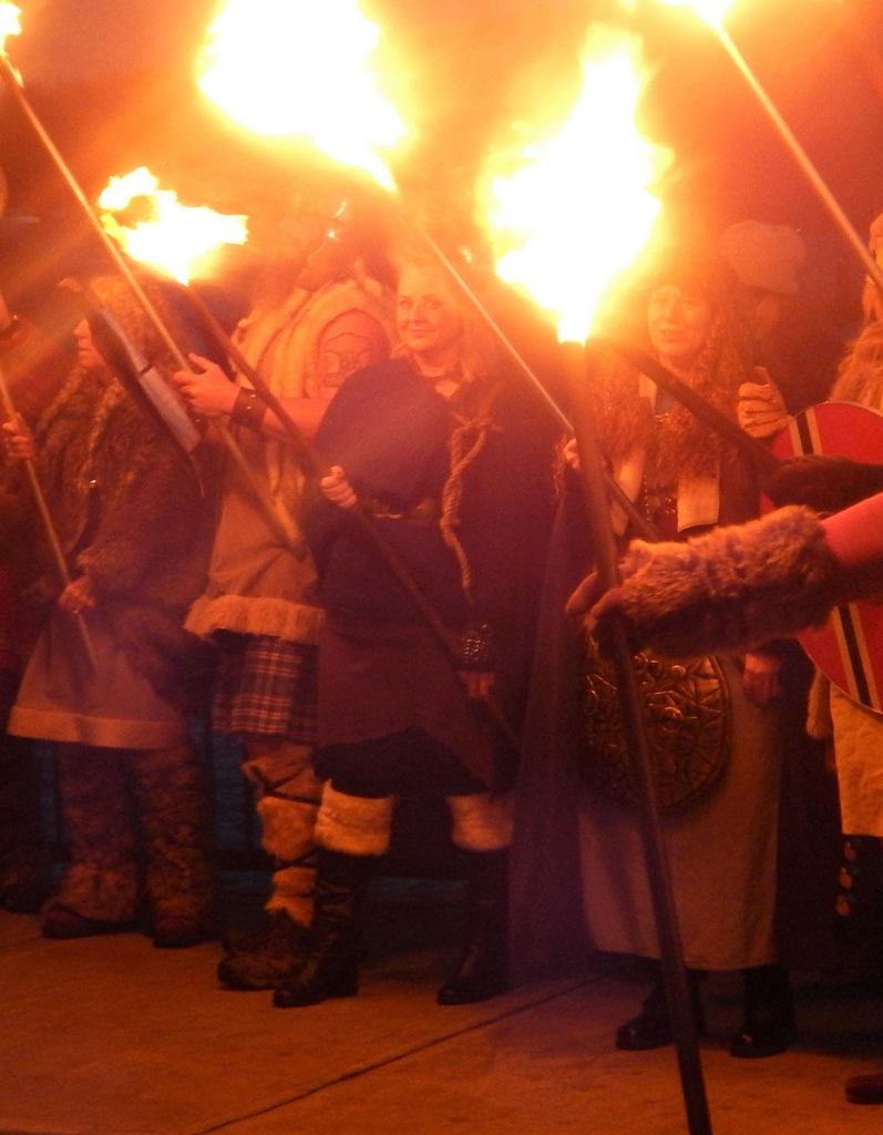 Faces glow from the torch light during the Julefest celebration, Dec. 3 at Muriel Iverson Williams Waterfront Park. (Angie Donovan/Kitsap News Group correspondent)