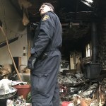 Deputy Fire Marshal Shawn Shepherd of the Kitsap County Fire Marshal&rsquo;s Office examines the scene after firefighters finish their work squelching a blaze in a small Suquamish home Jan. 7. (Photo/North Kitsap Fire & Rescue)