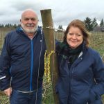 Nick and Sheila Nicholas of Anam Cara Cellars in Newberg, Oregon, stand in front of the six-acre block of vineyards they planted in the Chehalem Mountains American Viticultural Area. (Photo by Eric Degerman/Great Northwest Wine)