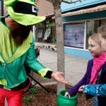 Girls spectating the 2016 Bremerton St. Patrick&rsquo;s Day parade receive gold coins from a participant.                                Michelle Beahm / Kitsap News Group
