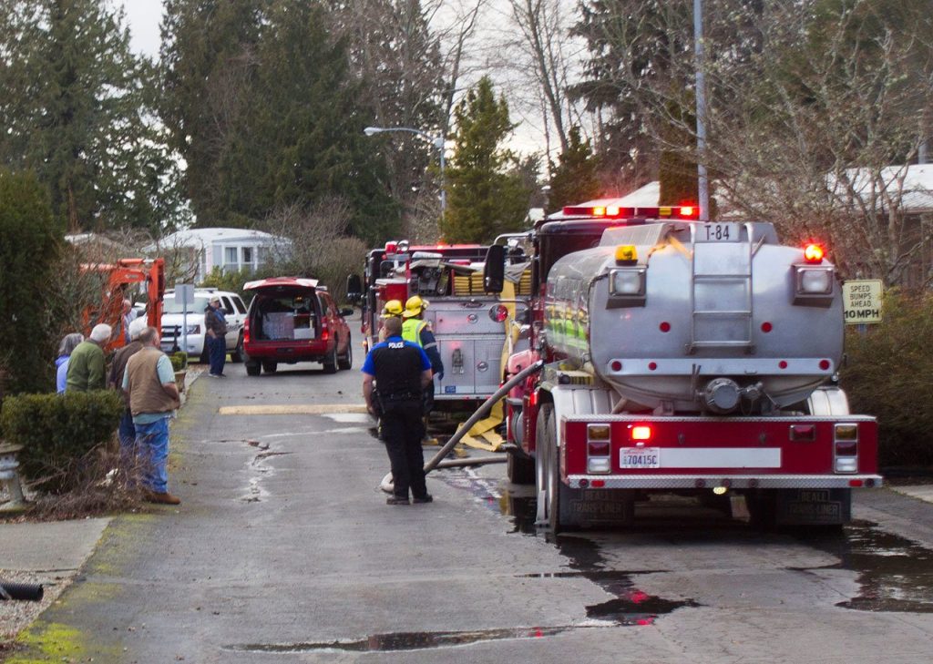 Cedar Glen residents watch as firefighters respond to a fire at the mobile home park Feb. 21. Sophie Bonomi / Kitsap News Group