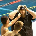 Kingston head swim coach Mark VanHuis demonstrates how to wear a swim cap at the Bucs&rsquo; state meet in 2016. (Patti Hoffer / Contributed)