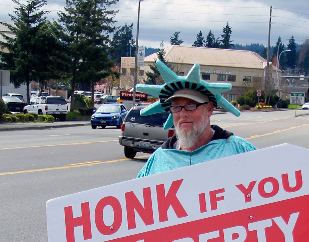Larry Stigall is a sign waver. To do his three-hour shift, he has to ride nearly five hours on the bus.                                Terryl Asla/Kitsap News Group