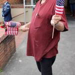&ldquo;Here&rsquo;s your flag.&rdquo; Volunteer Paul Villaire, a third-generation member of the American Legion, personally saw to it that every member of the welcoming crowd had an American flag to wave. (Terryl Asla/ Kitsap News Group)