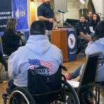 TSgt. Daniel Fye, at the podium, tells of the challenges of leading a normal life &mdash; and the blessing of soon having a home that will enable him to lead a normal life. In the foreground, one of a number of members of the Homes for Our Troops &ldquo;family&rdquo; of homeowners who traveled from as far away as Arizona to show their support. (Terryl Asla/ Kitsap News Group)