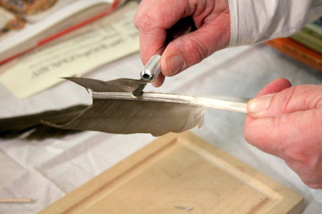SCA member Ela Pennayth Y Ynis Dewi carves a quill from a goose feather.                                Michelle Beahm / Kitsap News Group