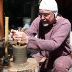 Arion the Wander demonstrates how, when striking a coin, one person usually holds the top and bottom dyes while a second strikes the coin to imprint the design on both sides.                                Michelle Beahm / Kitsap News Group