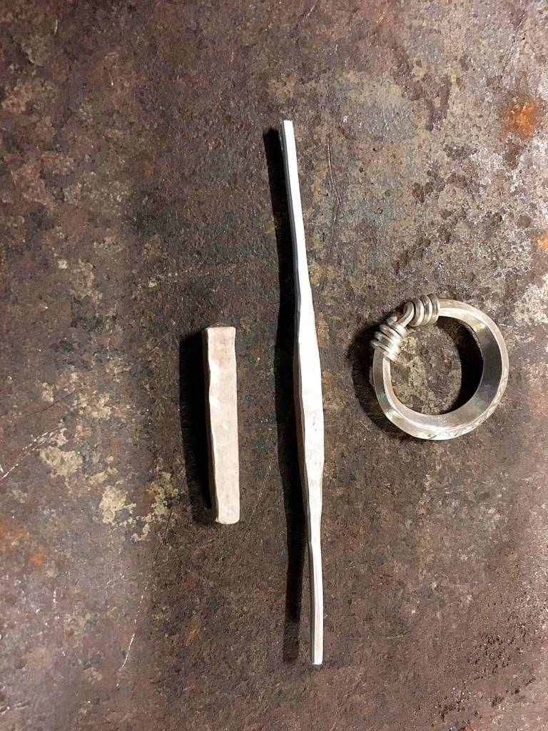 The three stages of silver jewelry making: silver bar, shaped line and finished ring, created by David Meyers, a blacksmith, blade smith and silver smith with the Kingdom of An Tir.                                Photo courtesy David Meyers