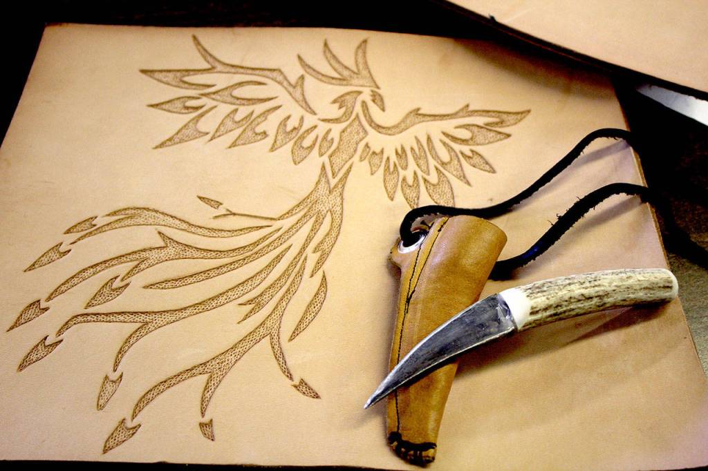 A handmade knife and a hand carved design in leather that will be turned into a mug.                                Michelle Beahm / Kitsap News Group