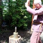 Arion the Wanderer strikes a coin with a six-pound hammer. Normally a second person would be holding the coin dyes he&rsquo;ll strike, with a pewter coin in the middle, but alone Arion utilizes a cylinder that will hold them together instead.                                Michelle Beahm / Kitsap News Group
