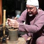 Arion the Wander demonstrates how, when striking a coin, one person usually holds the top and bottom dyes while a second strikes the coin to imprint the design on both sides.                                Michelle Beahm / Kitsap News Group