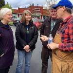 Charlotte Garrido, Kitsap County commissioner (far left) and organizer Tim Blair (far right) converse with area volunteers at the cottage build site in Port Orchard.                                Bob Smith | Kitsap News Group