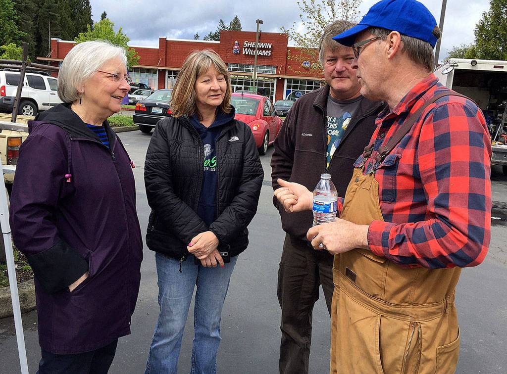 Charlotte Garrido, Kitsap County commissioner (far left) and organizer Tim Blair (far right) converse with area volunteers at the cottage build site in Port Orchard.                                Bob Smith | Kitsap News Group