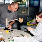 A child and caregiver create a hydraulic lift at Summer STEAM at the Naval Undersea Museum in 2016.                                Photo courtesy of the U.S. Naval Undersea Museum