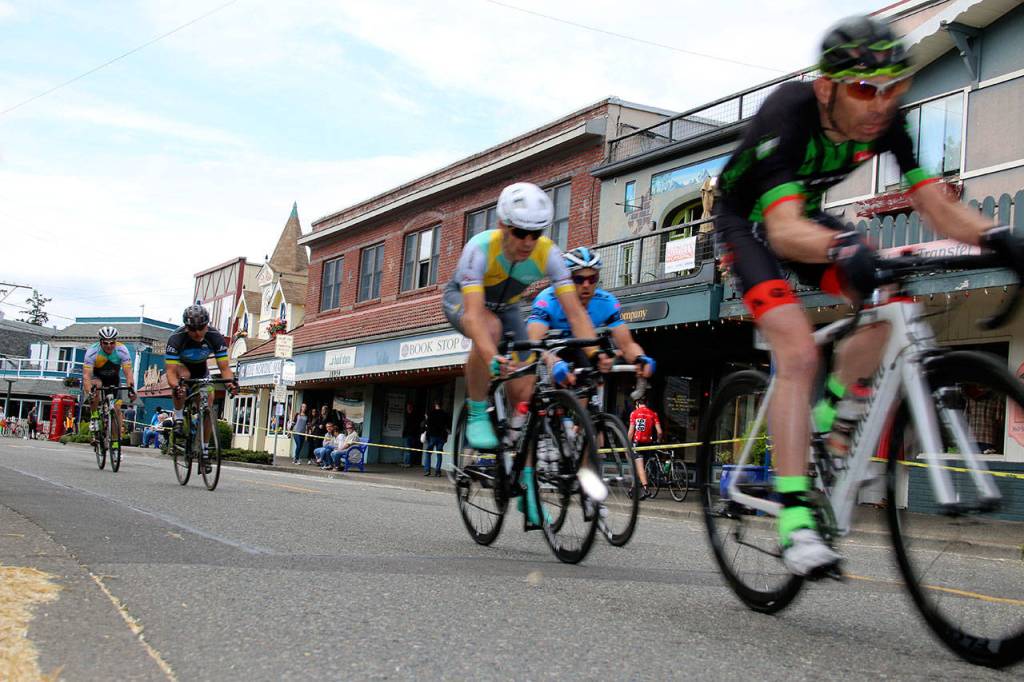 As cyclists raced past Nordic storefronts on narrow downtown Front Street, spectators sipped coffee drinks from sidewalk tables or enjoyed tapas in an outdoor dining area set up in front of Burrata Bistro. This could have been a European city. But this was a Saturday afternoon in Poulsbo, and the event was the Poulsbo Twilight Criterium. (Richard Walker/Kitsap News Group)