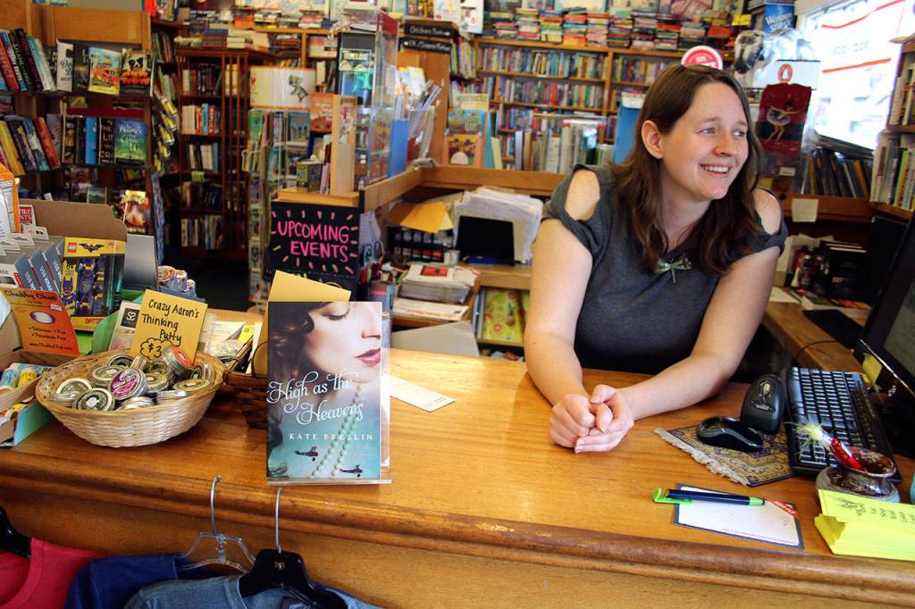 Kate at Liberty Bay Books watches the Poulsbo Twilight Criterium from inside the store, June 3. (Richard Walker/Kitsap News Group)