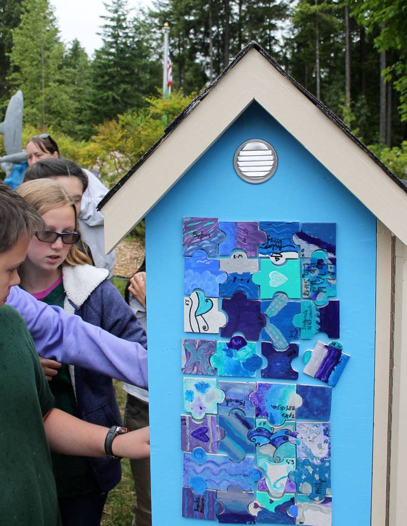 Every fifth grader painted at least one puzzle tile. The tiles were then glued to three sides of the Little Free Library.                                Terryl Asla/Kitsap News Group.