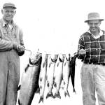Two fishing buddies show off their catch in the mid- to late-1950s.