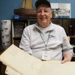 Jim Shields, grandson of Capt. J.E. Shields, holds one of his grandfather&rsquo;s log books, which are stored in the archives of the Poulsbo Maritime Museum.  Terryl Asla/Kitsap News Group