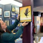 Liberty Bay co-owner Brooke Dalton hangs a work by artist Leigh Knowles, formerly of Magal & Louis Gallery.                                 Terryl Asla/Kitsap News Group