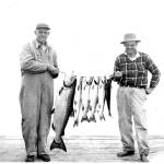 Two fishing buddies show off their catch in the mid- to late-1950s.