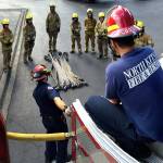 NKF&R Lieutenants Michael Mock (front left) and Mark Cooney (front right) discuss hose-loading with the 2016 academy&rsquo;s volunteer-intern recruits. During NKF&R&rsquo;s annual three-month training academy, recruits spend at least four days per week in the classroom and on the drill ground where they learn the essential skills involved in firefighting. (NKF&R / contributed)