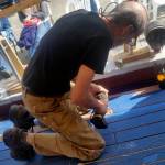 Shipwright Scott Kimmett puts in the final screws fastening down the last plank &mdash; the &ldquo;whiskey plank&rdquo; &mdash; on the deck of the Kitsap tall ship, &ldquo;Fiddler&rsquo;s Dream,&rdquo; that is undergoing reconstruction at the Brownsville Marina. The blue masking tape on the deck planks is to keep them clean when workers caulk the seams between the planks with cotton yarn and caulking compound. The caulking between the boards will allow the deck to remain waterproof even when the wood planks expand or shrink.                                Terryl Asla|Kitsap News Group