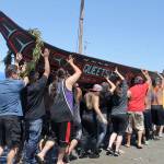Volunteers carry a canoe from Queets, on the Pacific Coast, out of the tideline at Point Julia during the 2016 Canoe Journey. (Richard Walker)