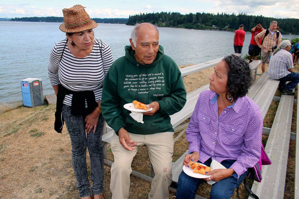 Suquamish Tribe culture-bearer Ed Carriere shares what the Canoe Journey means to indigenous peoples. &ldquo;When I was young, the canoes were gone,&rdquo; he said. &ldquo;In the 1920s, &rsquo;30s and &rsquo;40s, nobody traveled by canoe anymore.&rdquo; With him, from left, are Marylin Bard, daughter of Canoe Journey founder Emmett Oliver, of Kingston; and Georgia George, Suquamish. (Richard Walker/Kitsap News Group)